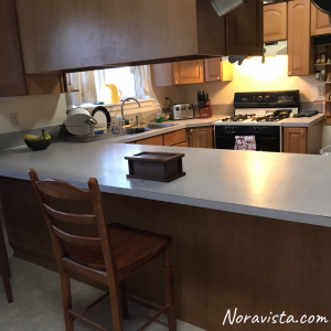 A clean kitchen with laminate countertops and builders grade cabinets