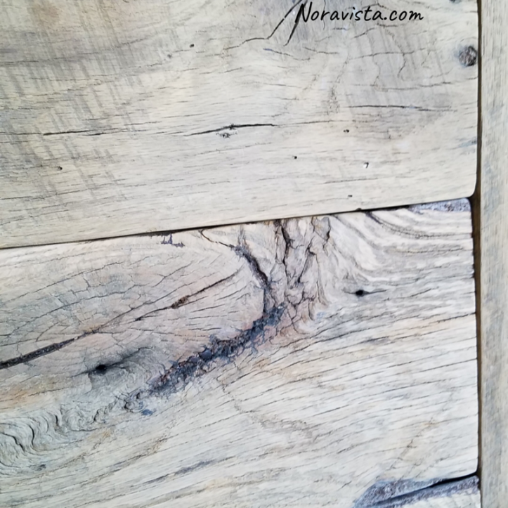 A close up view of a reclaimed oak barn wood cabinet drawer with saw tooth marks, knots and cathedrals 